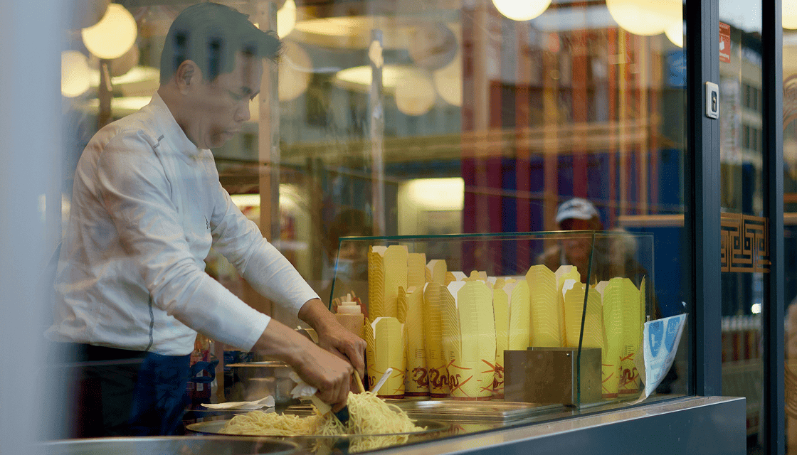 A cook packing takeaway orders at the kitchen pass
