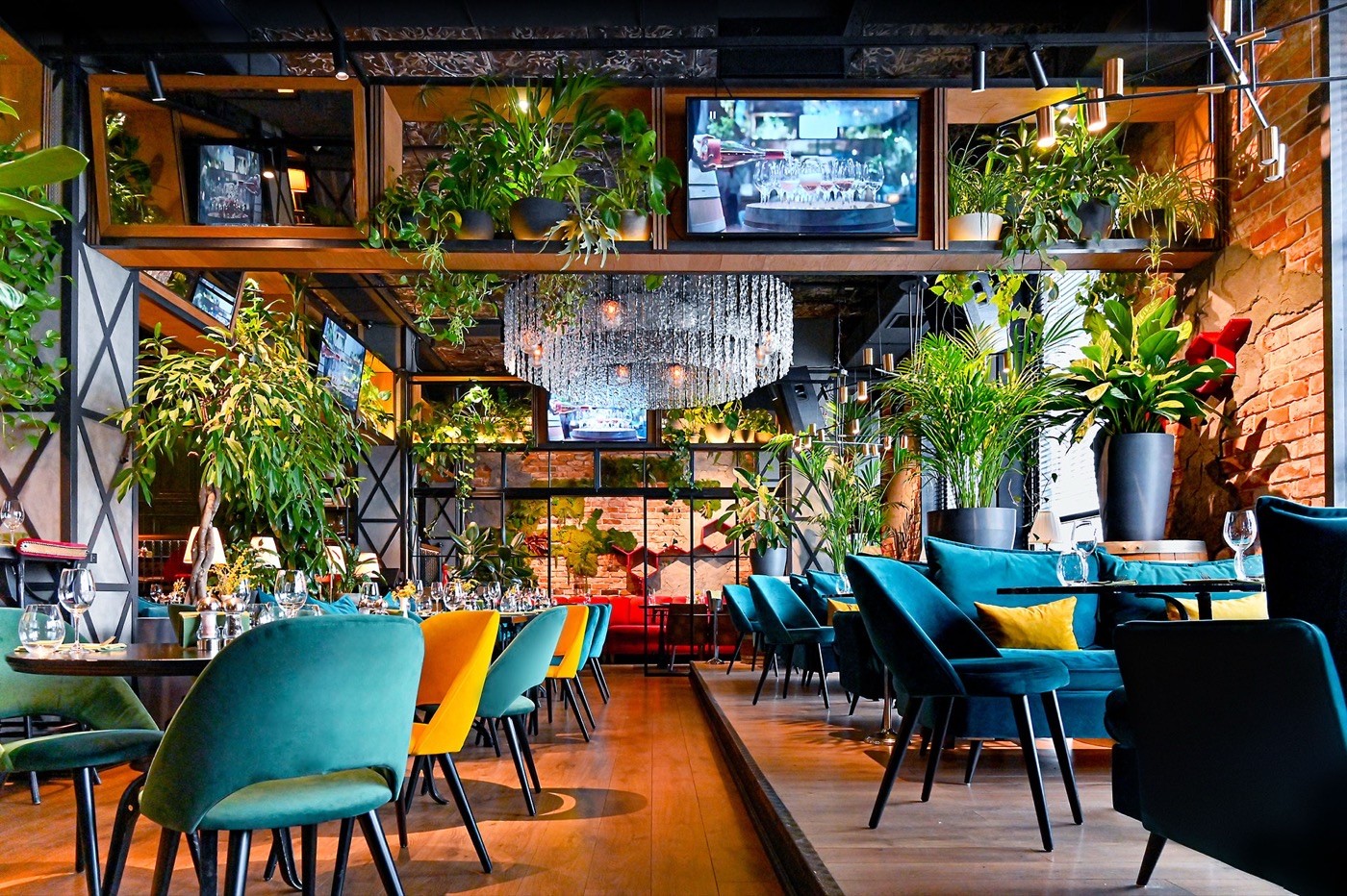 A restaurant dining room with set tables and green chairs
